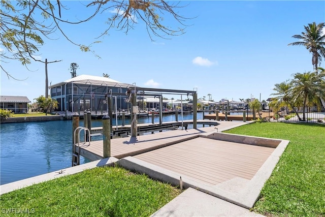 dock area with a yard, fence, a water view, and boat lift