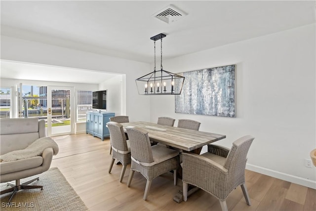 dining area featuring light wood-type flooring, visible vents, baseboards, and french doors