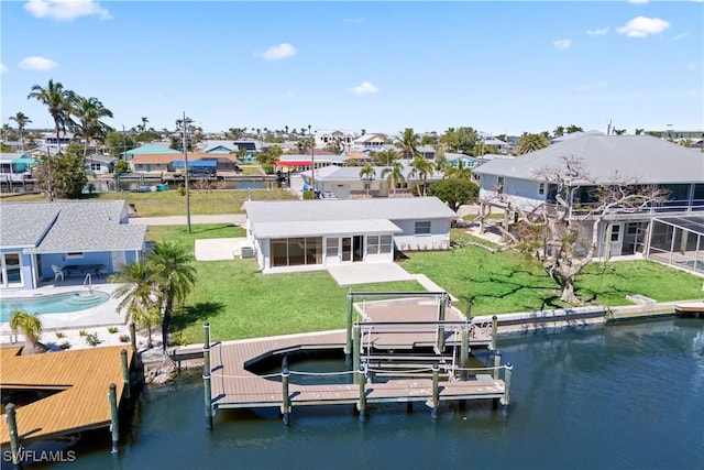 view of dock featuring a yard, a residential view, boat lift, and a water view