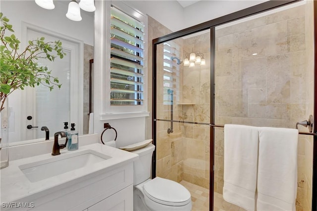 bathroom featuring a stall shower, vanity, and toilet