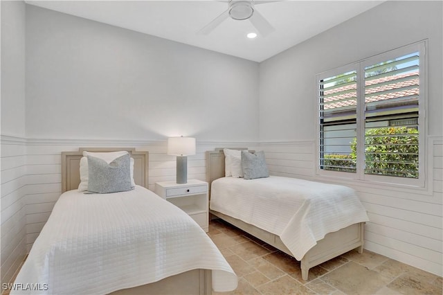 bedroom featuring recessed lighting, stone finish flooring, a wainscoted wall, and ceiling fan