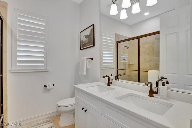 bathroom with a stall shower, a sink, toilet, and double vanity