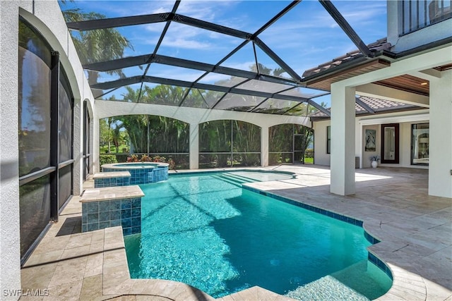 view of pool with glass enclosure, a pool with connected hot tub, and a patio