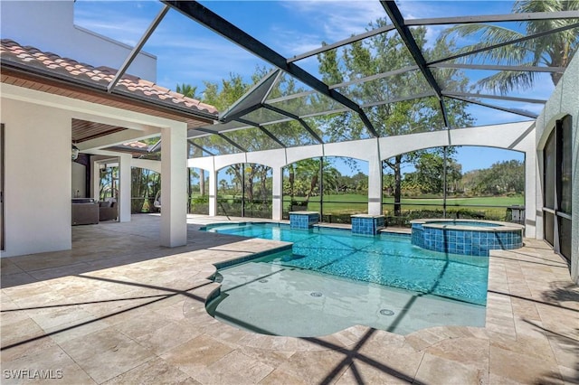 view of pool with a patio, glass enclosure, and a pool with connected hot tub