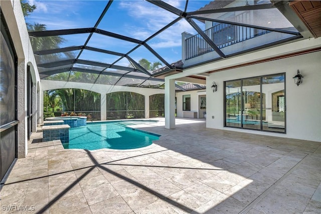 view of pool with a patio area, a pool with connected hot tub, and glass enclosure