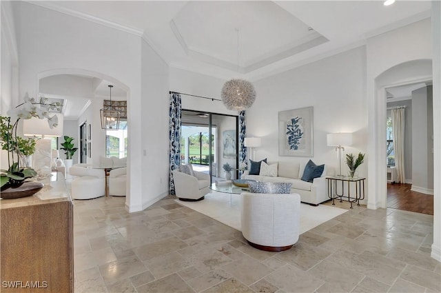 living room featuring a towering ceiling, baseboards, and stone tile flooring