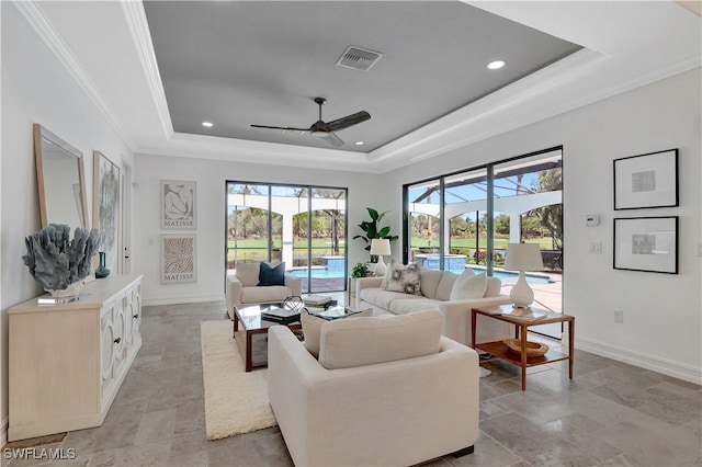 living room with recessed lighting, visible vents, baseboards, a tray ceiling, and crown molding