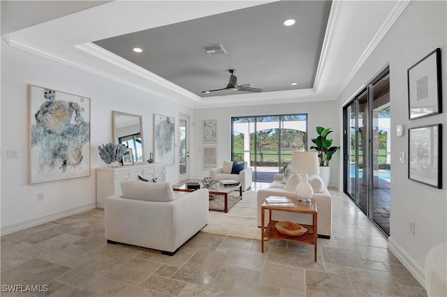 living area with a raised ceiling, visible vents, crown molding, and baseboards