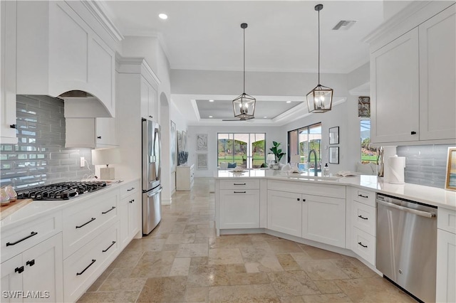 kitchen featuring stainless steel appliances, visible vents, white cabinets, a sink, and a peninsula