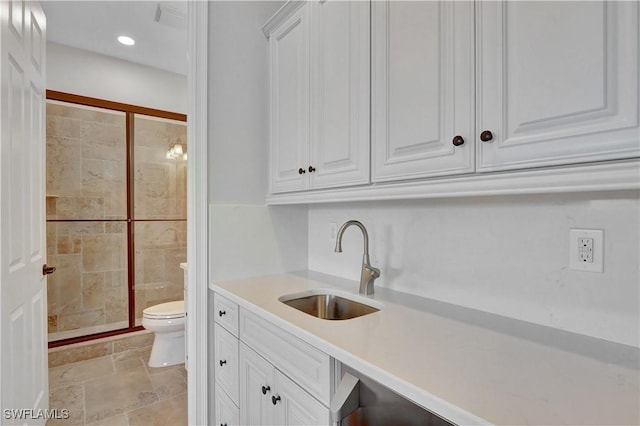 bathroom with toilet, recessed lighting, vanity, stone finish flooring, and a stall shower