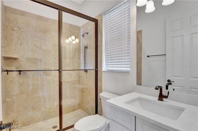 full bathroom with a stall shower, vanity, and toilet