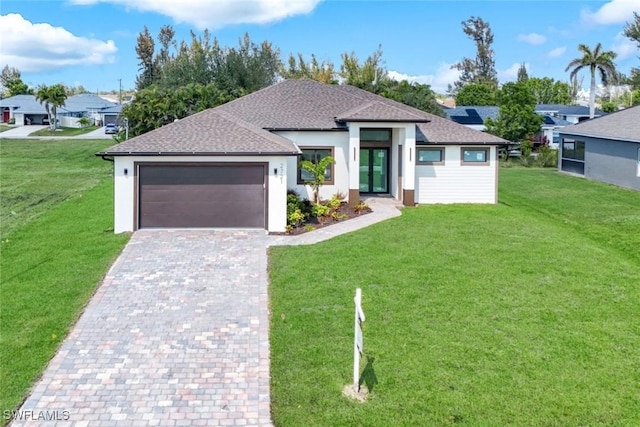 view of front of home featuring decorative driveway, a garage, a front yard, and stucco siding