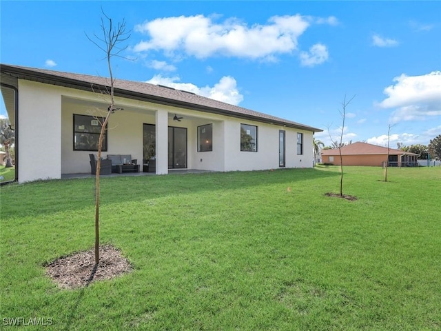 back of property featuring an outdoor living space, ceiling fan, a lawn, stucco siding, and a patio area