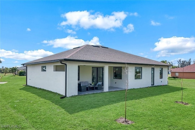 back of property with an outdoor living space, a yard, a patio area, and stucco siding