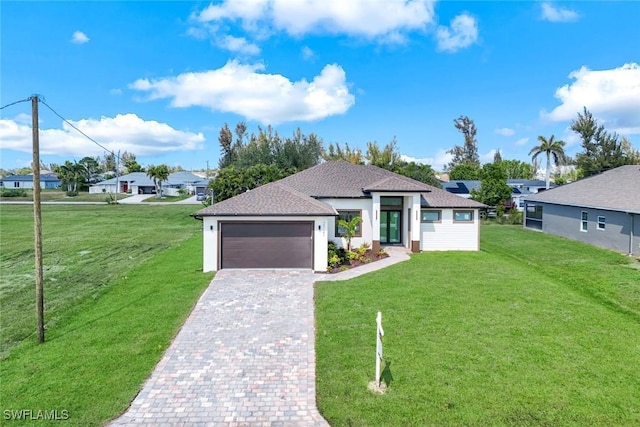 view of front of house featuring a front lawn, decorative driveway, and a garage