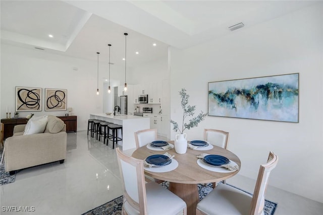 dining room with a raised ceiling, recessed lighting, and visible vents