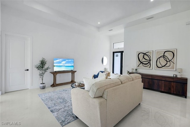 living area featuring a wealth of natural light, a tray ceiling, a high ceiling, and recessed lighting