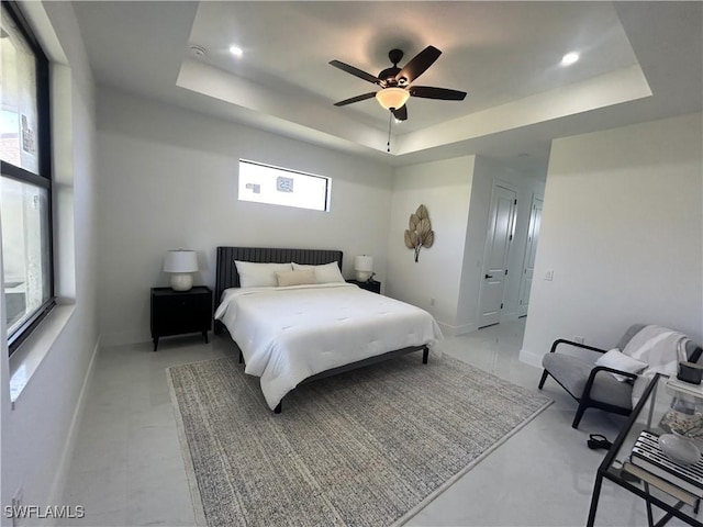 bedroom with a tray ceiling, baseboards, and ceiling fan