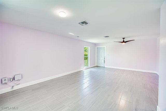 unfurnished room featuring light wood-style floors, baseboards, and visible vents