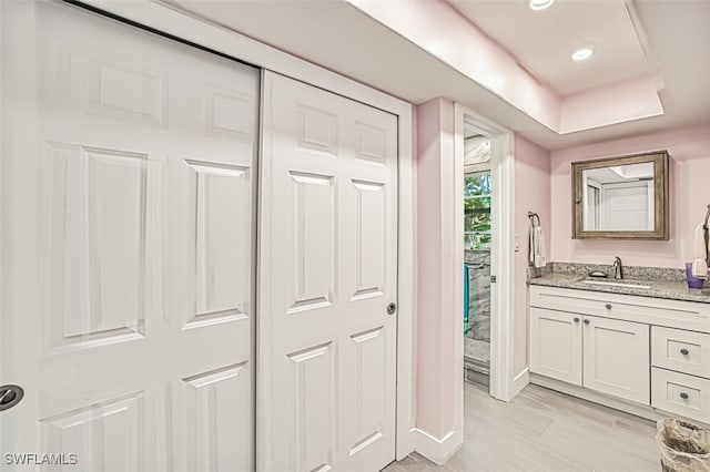 bathroom with recessed lighting, vanity, and wood finished floors