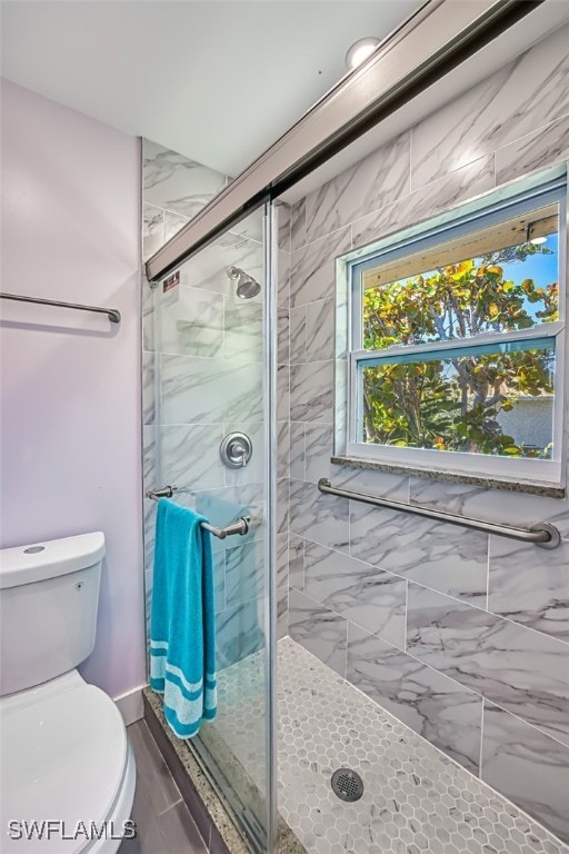 bathroom featuring toilet and a stall shower