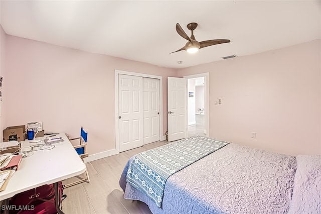 bedroom with a ceiling fan, visible vents, baseboards, light wood-style flooring, and a closet