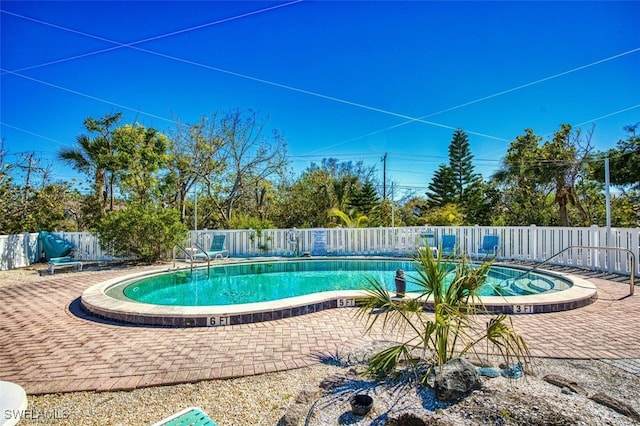 community pool featuring a patio area and a fenced backyard