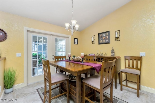 dining space featuring lofted ceiling, baseboards, a notable chandelier, and french doors