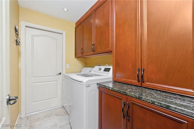 clothes washing area featuring light tile patterned flooring, cabinet space, and separate washer and dryer