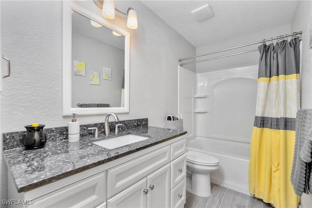 full bathroom featuring toilet, a textured wall, shower / bath combination with curtain, and vanity