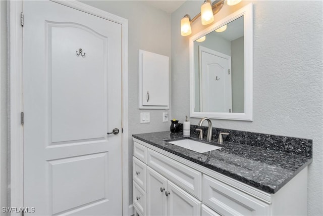 bathroom featuring a textured wall and vanity