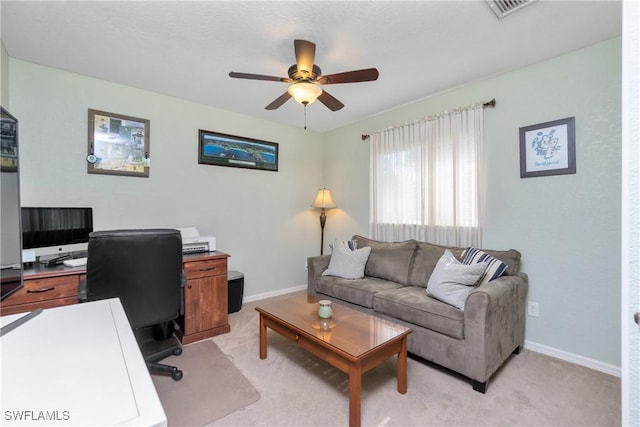 office area featuring light carpet, ceiling fan, visible vents, and baseboards