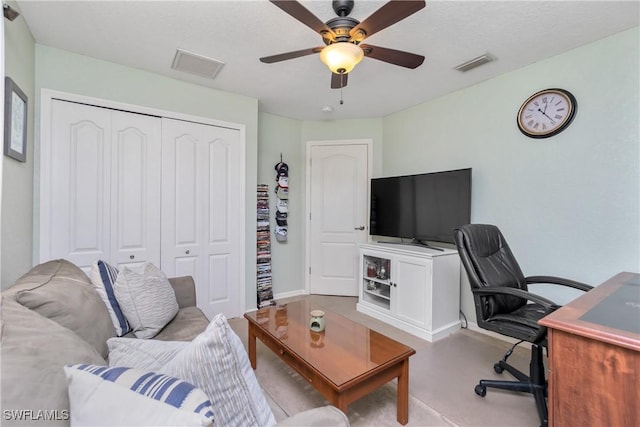 living area with visible vents and a ceiling fan