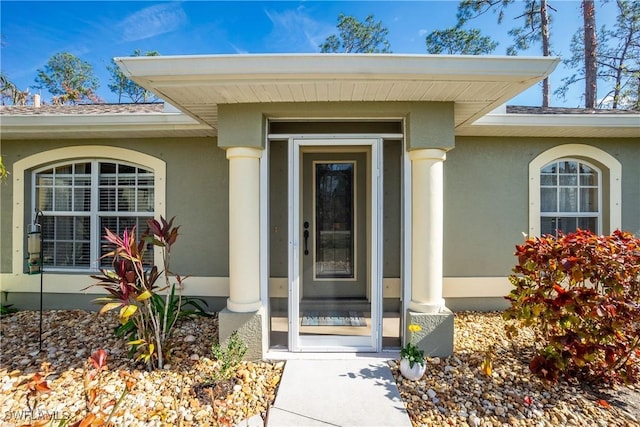 view of exterior entry with stucco siding