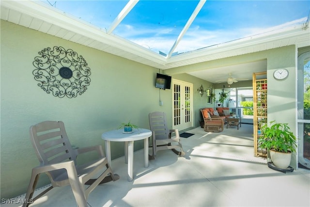 view of patio with a ceiling fan, french doors, and a lanai