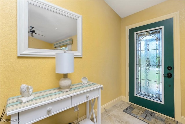 entrance foyer featuring light tile patterned floors, a ceiling fan, and baseboards