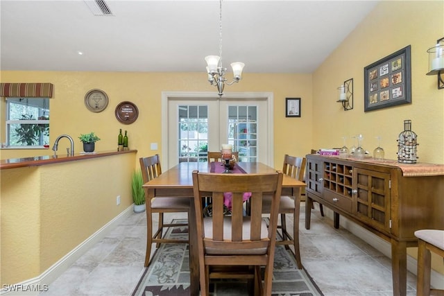 dining room with visible vents, a notable chandelier, and baseboards