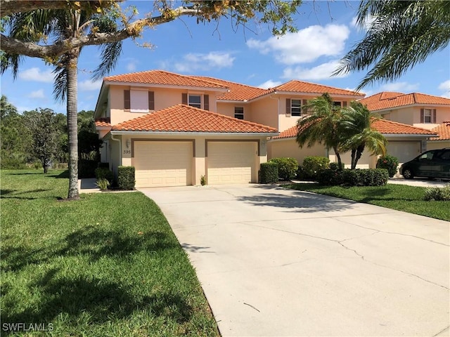 mediterranean / spanish house featuring a tiled roof, a front yard, stucco siding, a garage, and driveway