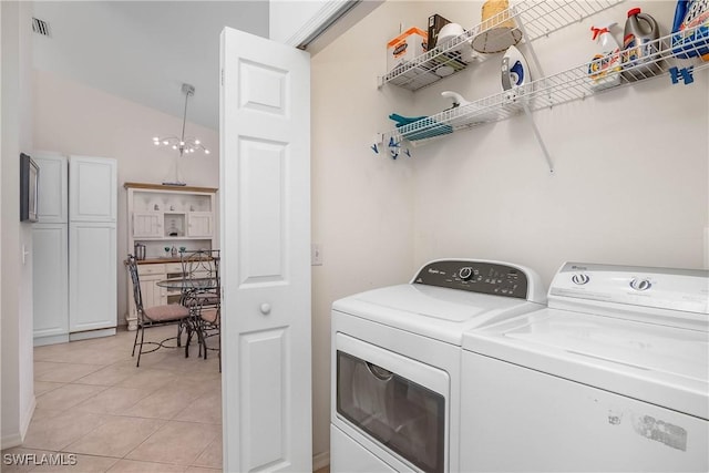 laundry room featuring laundry area, light tile patterned floors, visible vents, and washer and clothes dryer