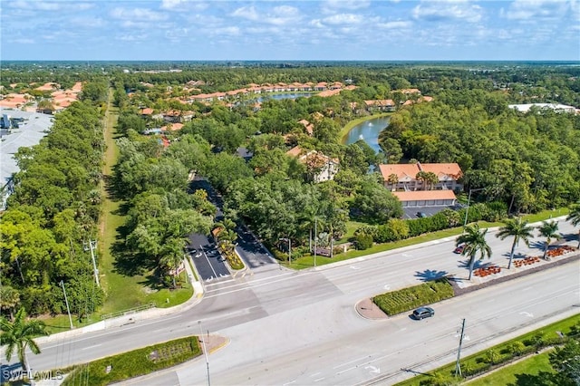 aerial view featuring a forest view and a water view