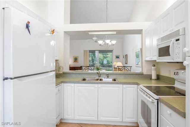 kitchen featuring white appliances, an inviting chandelier, a sink, light countertops, and white cabinetry