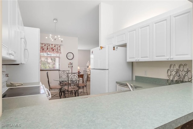 kitchen featuring pendant lighting, light countertops, a notable chandelier, white appliances, and white cabinetry