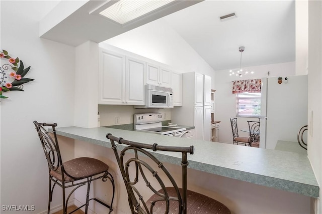 kitchen with white cabinetry, white appliances, a breakfast bar, and lofted ceiling