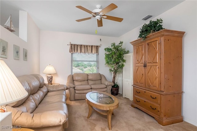 living area featuring a ceiling fan, visible vents, and light carpet