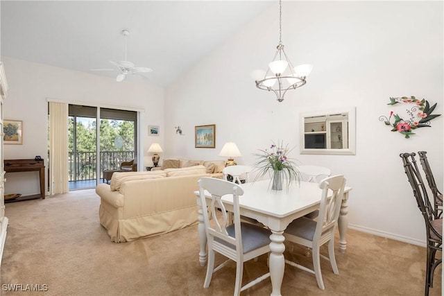 dining space with light carpet, ceiling fan with notable chandelier, high vaulted ceiling, and baseboards