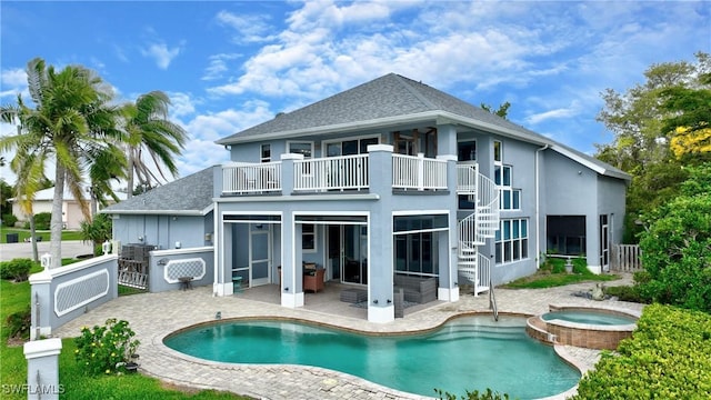 back of property featuring stairway, an outdoor pool, a patio, and an in ground hot tub