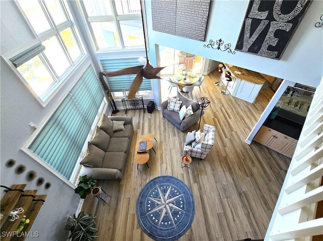 living area with a high ceiling and wood finished floors