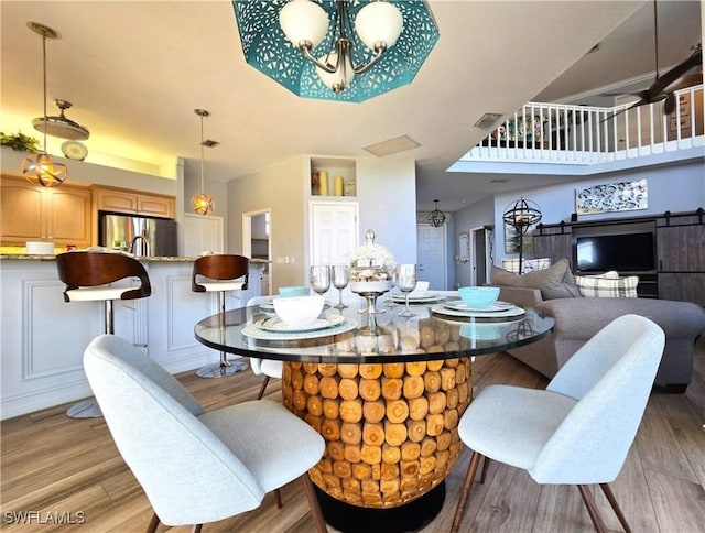 dining room featuring light wood-style flooring, visible vents, and a chandelier