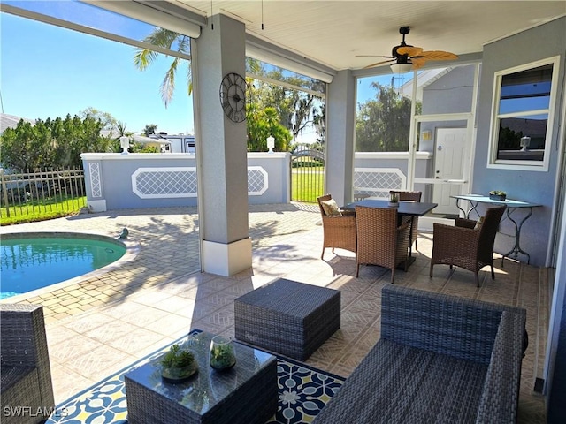 view of patio featuring ceiling fan, outdoor dining space, fence, and a fenced in pool