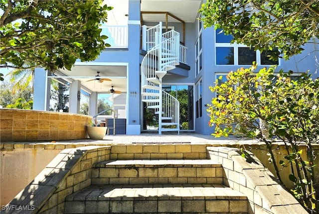 property entrance with a patio area, ceiling fan, and stucco siding